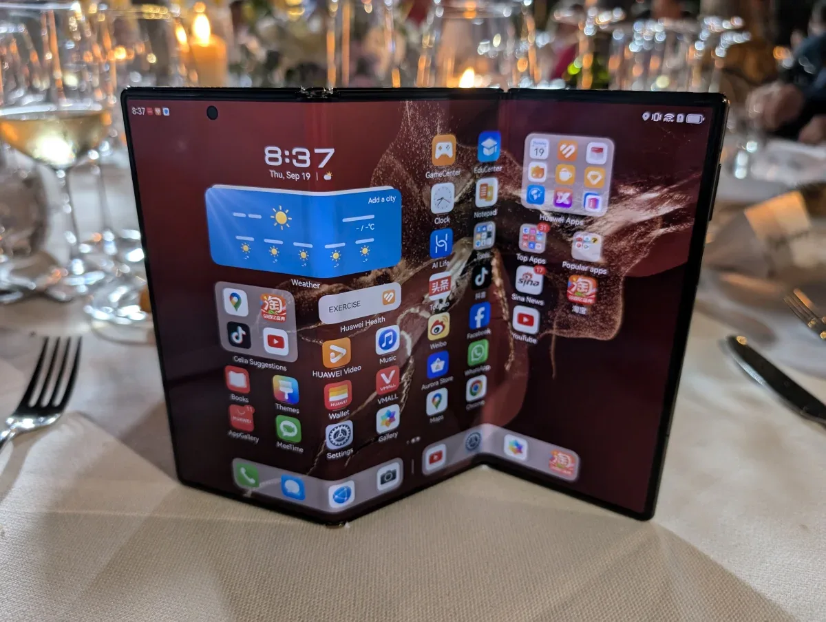 Üç katlı Huawei Mate XT telefonun açılmış hâlde masa üzerindeki görünümü