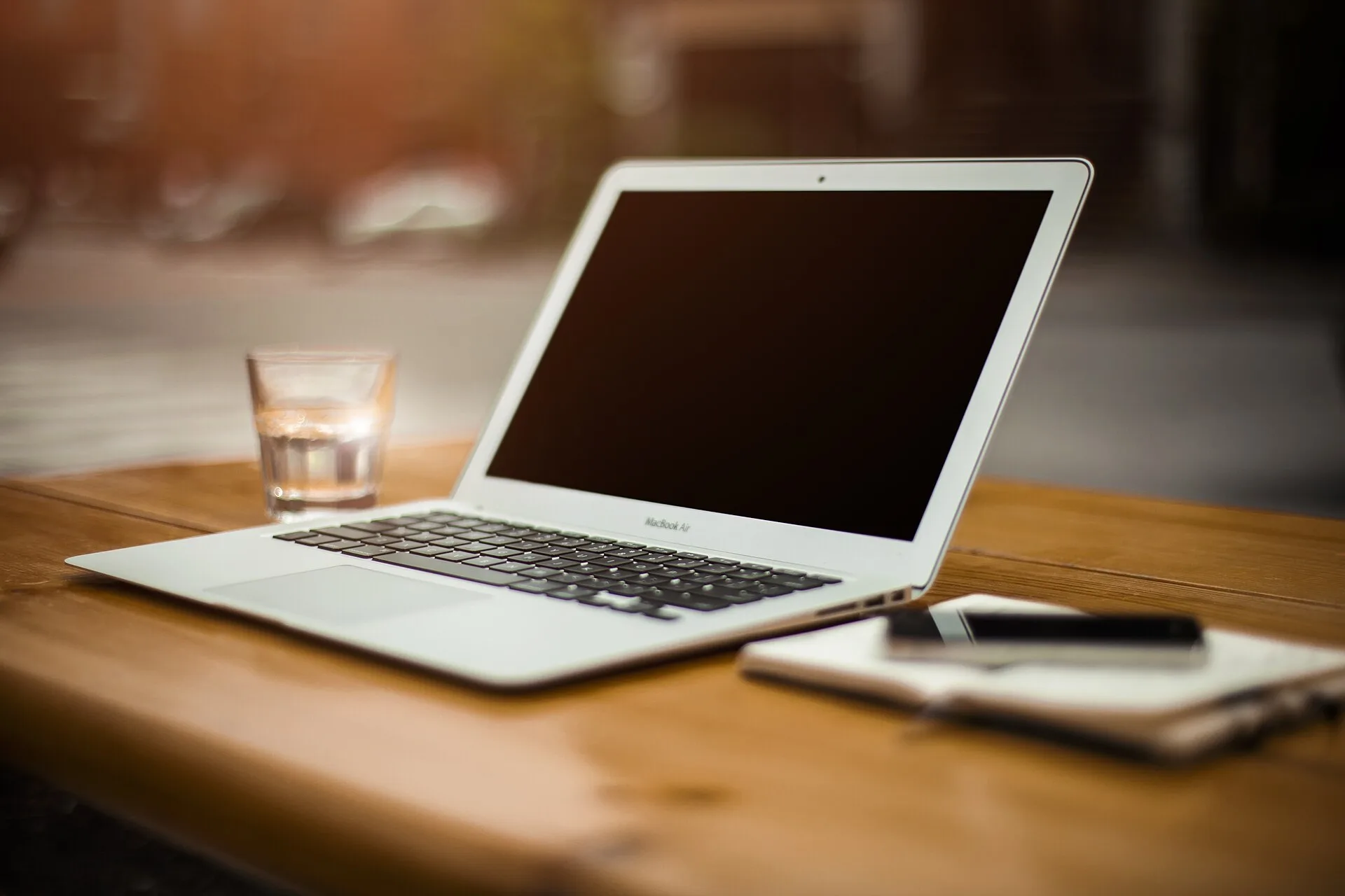 Ahşap masa üzerinde açık duran gümüş renkli bir MacBook Air