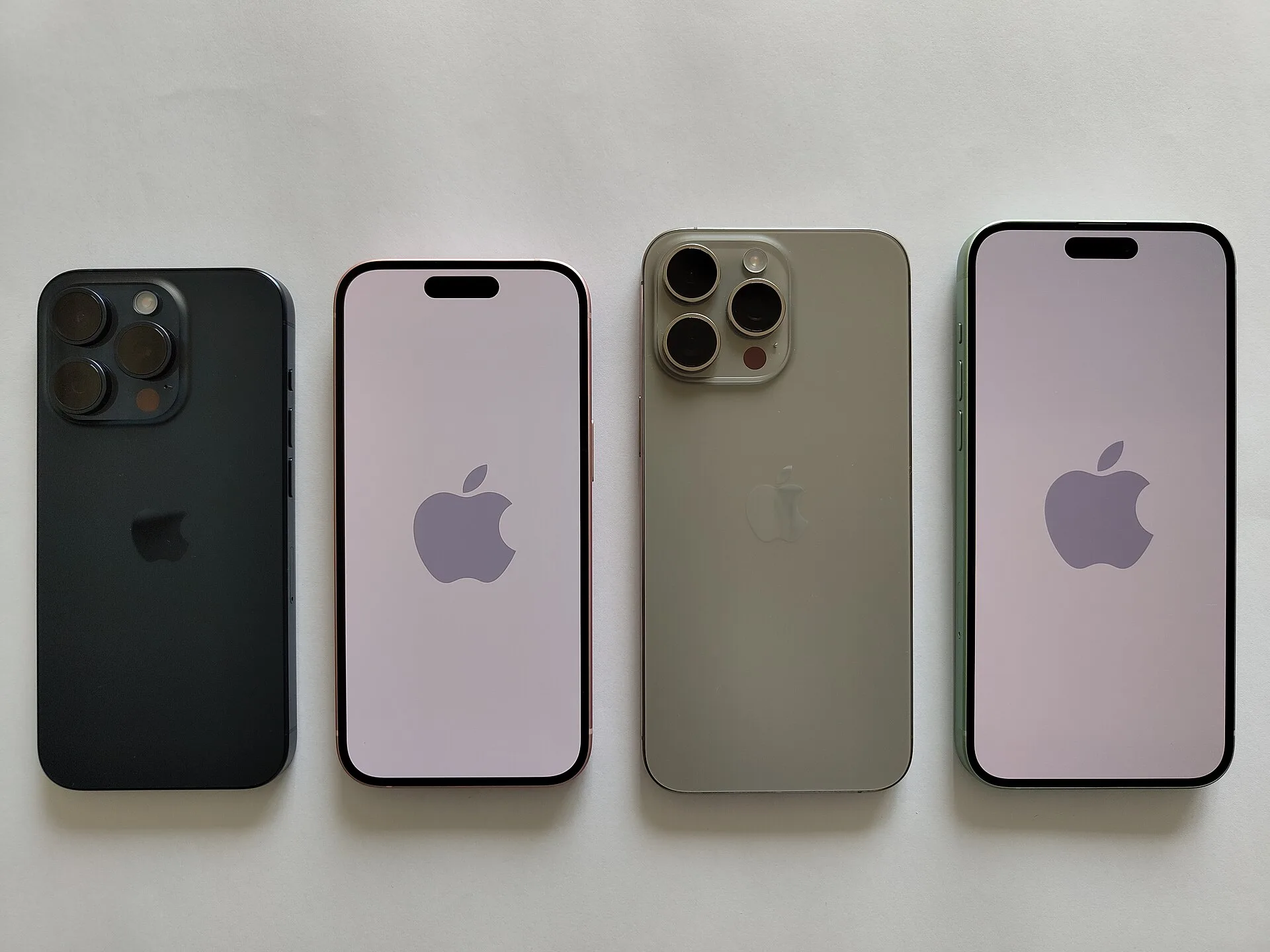 Farklı renklerde dört iPhone modeli yan yana