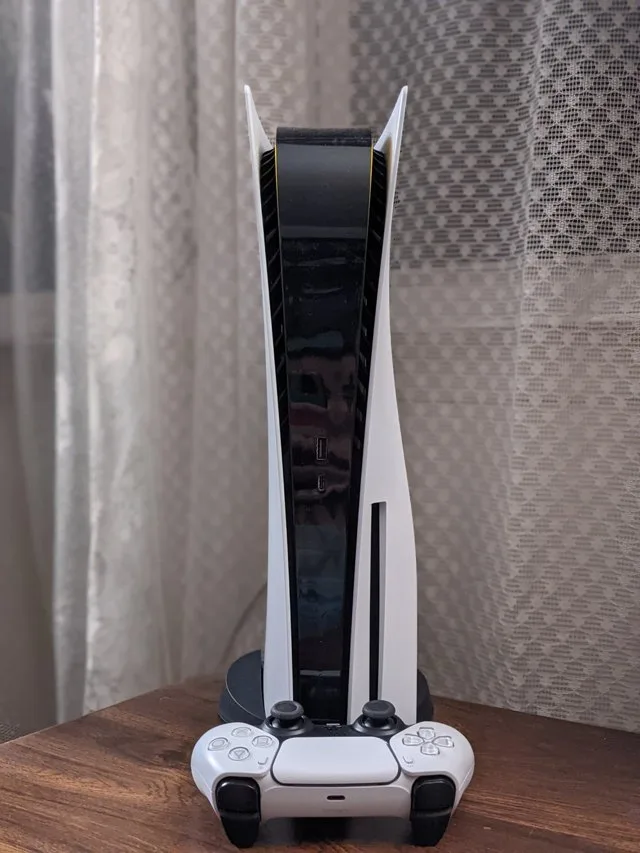 Dikey standında duran PlayStation 5 ve şarj olan DualSense kumandası