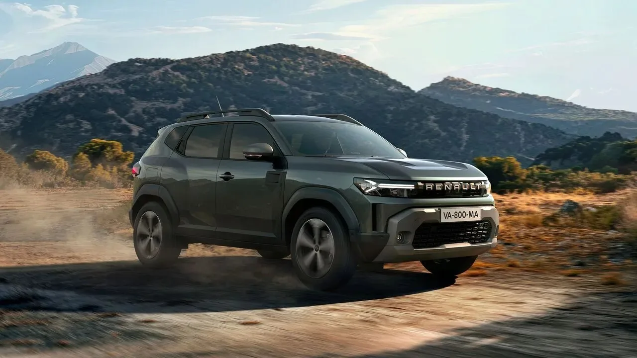 Koyu yeşil Renault Duster toprak yolda ilerlerken, arka planda dağlar