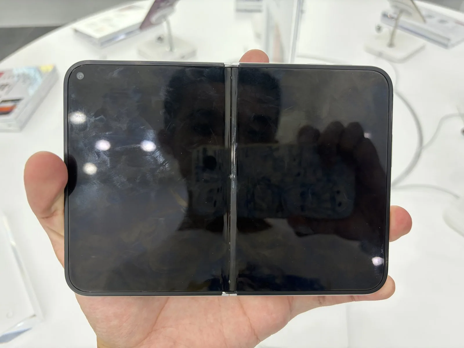 Yarı açık duran iPhone Duo, iç ekranda tarih ve saat görünüyor