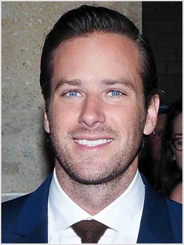 Dramatic scene of a male actor resembling Armie Hammer on a film set, portraying a modern vigilante in a dark alley, directed by Uwe Boll.