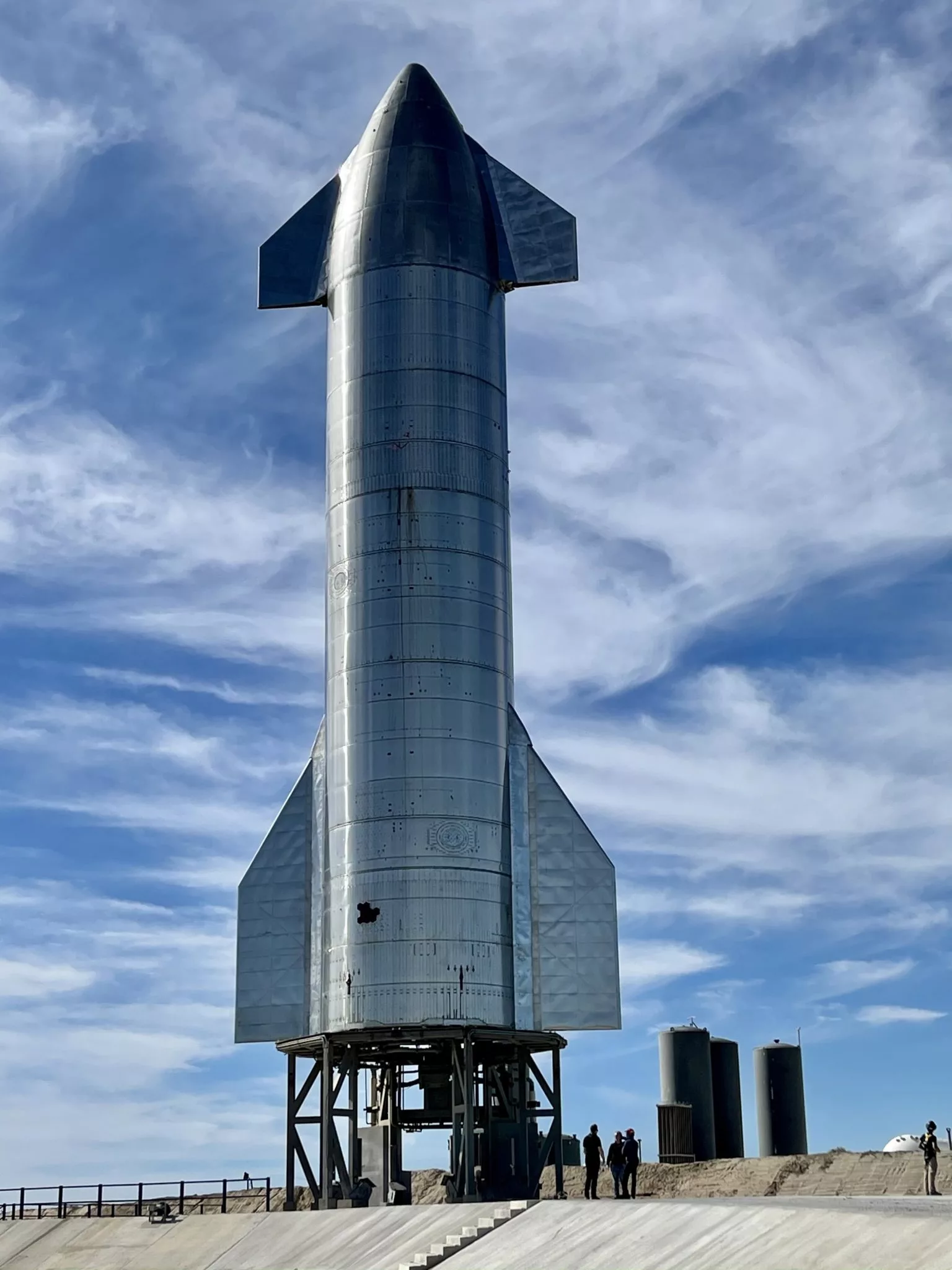 An artistic depiction of SpaceX Starship Flight 9 launch against a starry twilight sky.