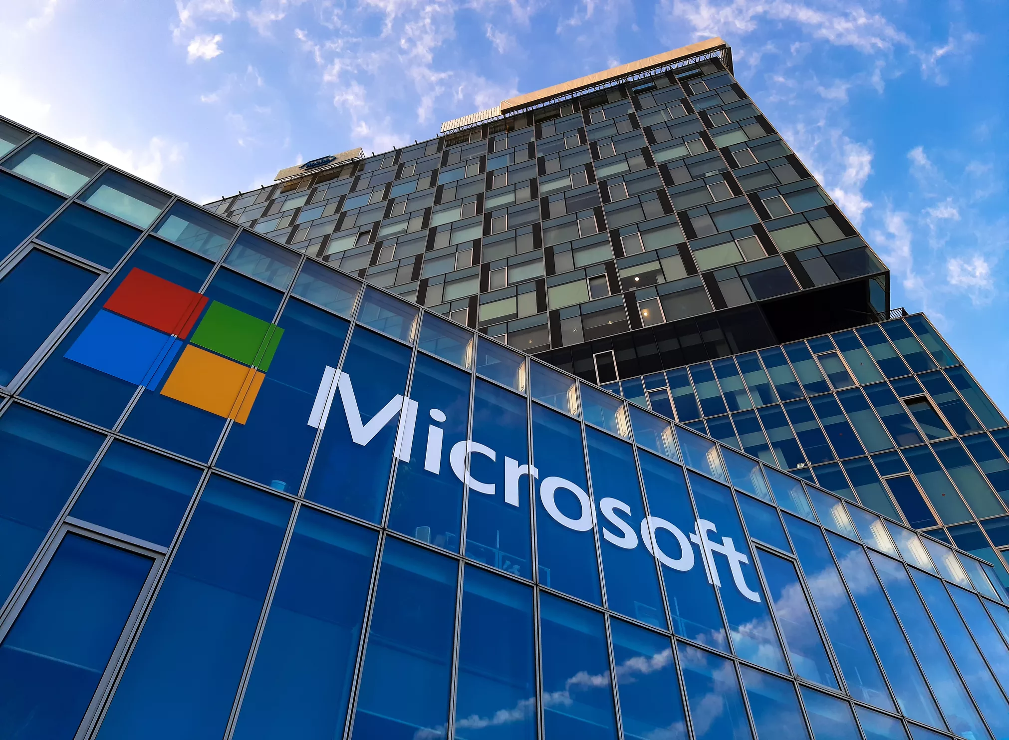 Modern illustration depicting Microsoft reducing workforce and streamlining operations with advanced technology in a collaborative office setting.
